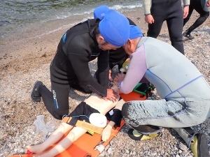 海から引き揚げた人形に心肺蘇生を施す