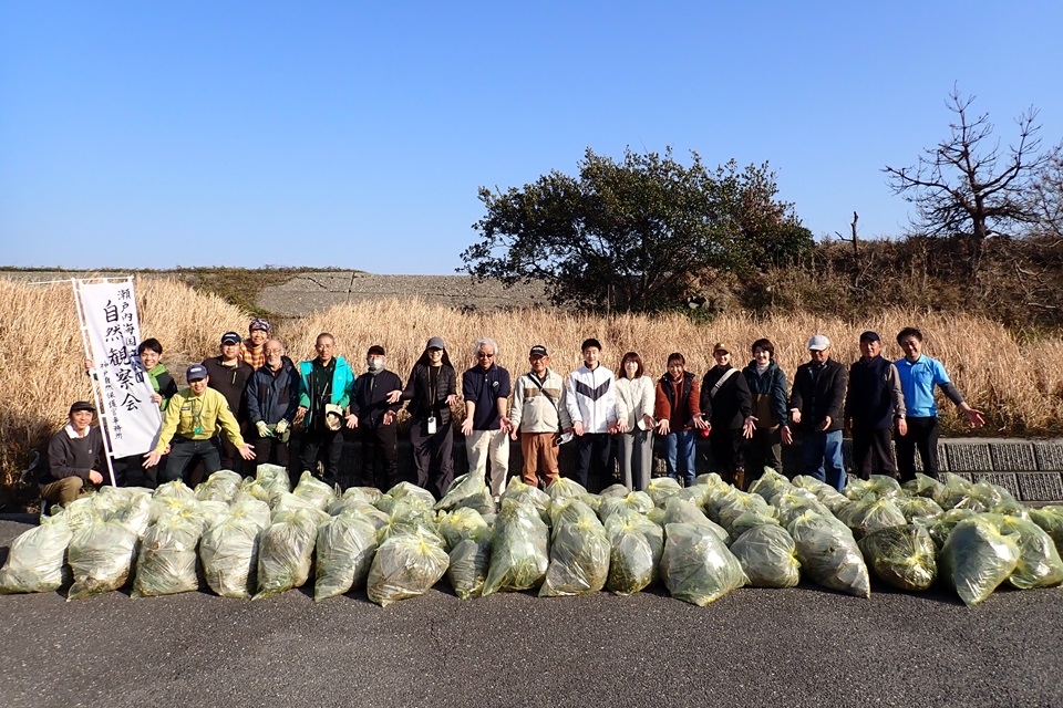 防除したナルトサワギクと一緒に記念撮影